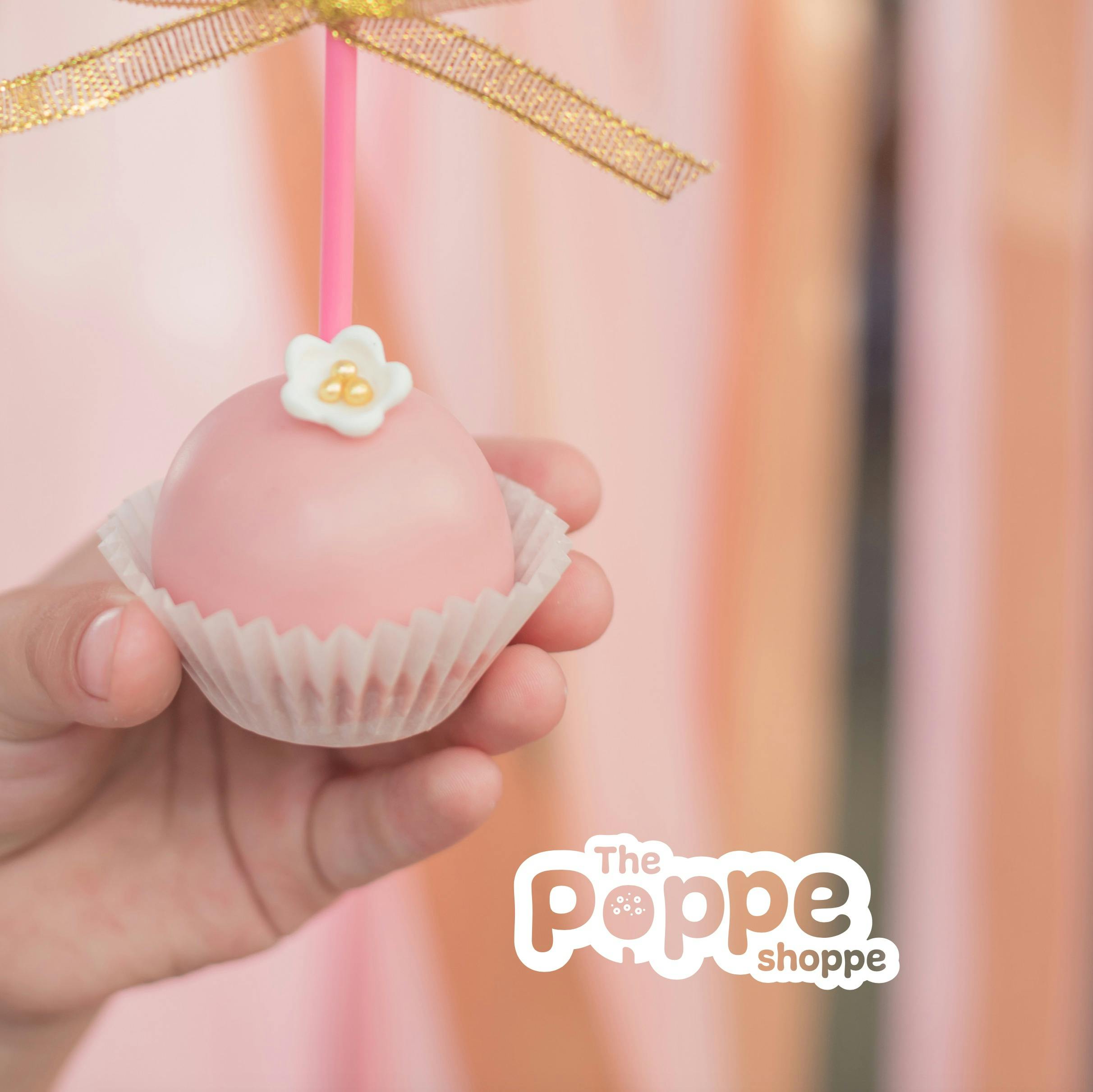 The Poppe Shoppe logo overlayed on a backdrop of a cake pop.